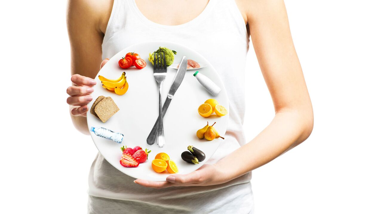 La fille tient une assiette de nourriture